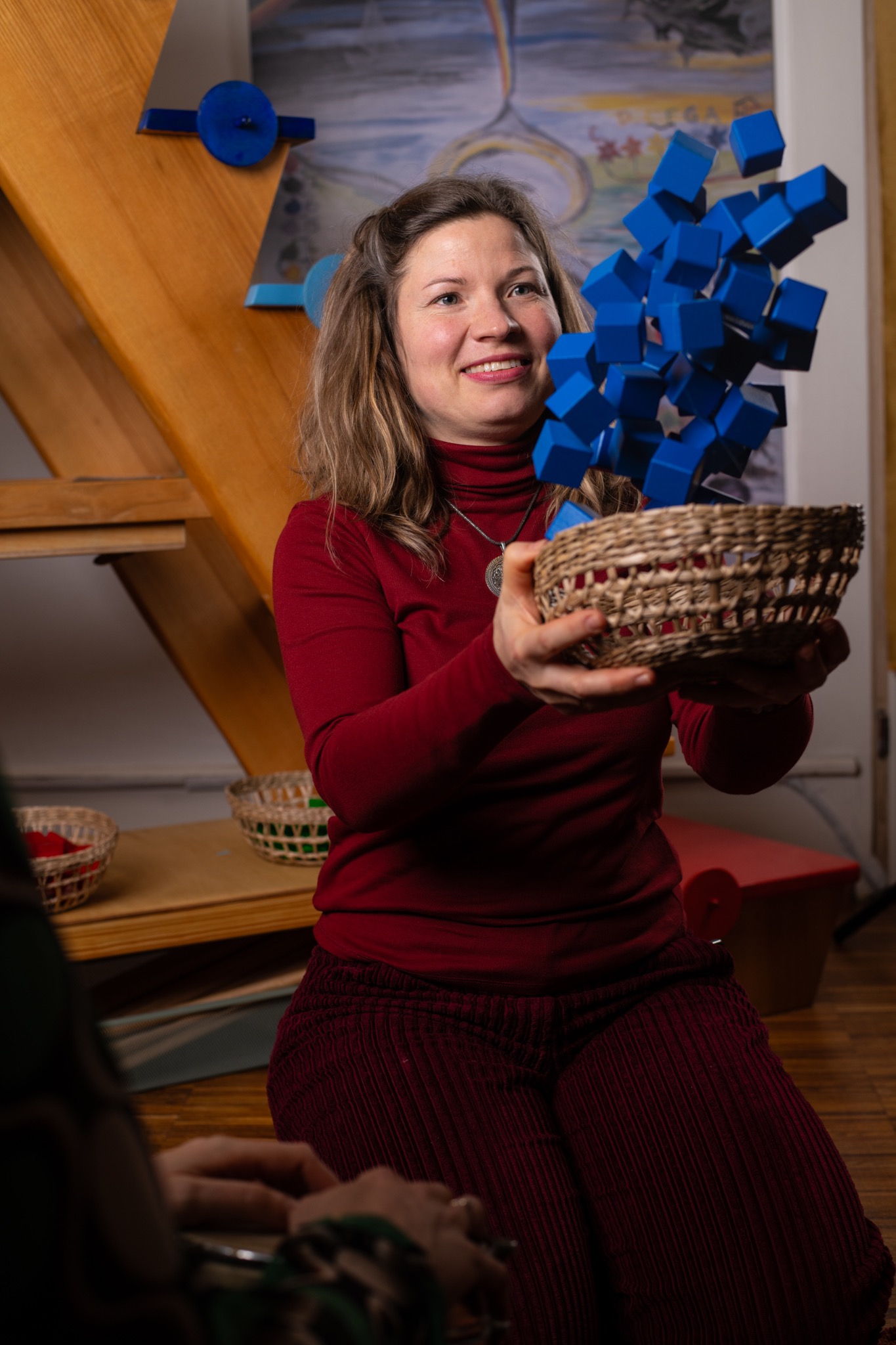 Eine Frau nimmt einen Korb mit bewegten blauen Würfeln aufmerksam auf